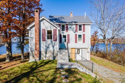 a house on a hill with a staircase in front at Lakeside Retreat in Orono, Maine in Orono