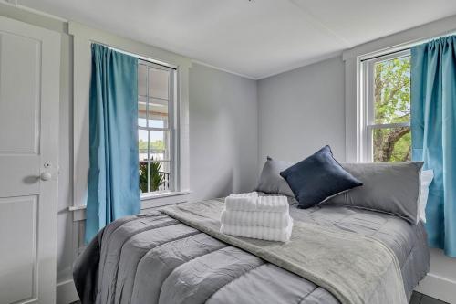 a bedroom with a large bed with blue curtains at Lakeside Retreat in Orono, Maine in Orono