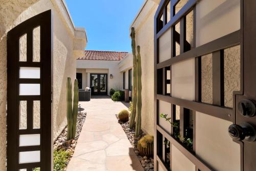 a courtyard of a home with a gate and a house at Golf Course Villa with Exceptional Views in La Quinta
