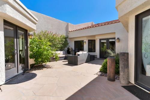 a patio of a home with a couch and windows at Golf Course Villa with Exceptional Views in La Quinta