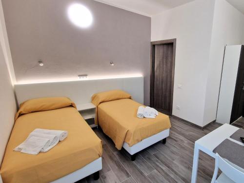 a small room with two beds and a table at Berica Alloggi Turistici in Vicenza