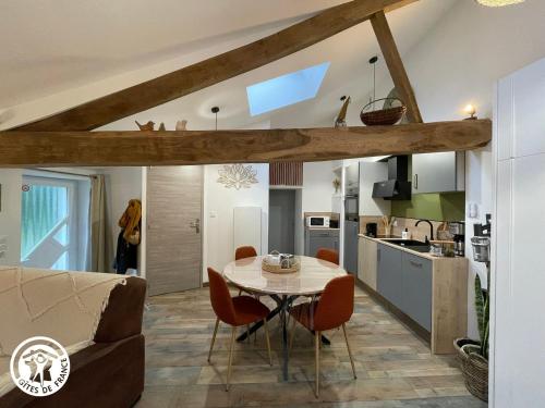une cuisine et un salon avec une table et des chaises dans l'établissement Charmant gîte en Vendée proche Puy du Fou - FR-1-426-566, à Saint-Hilaire-le-Vouhis
