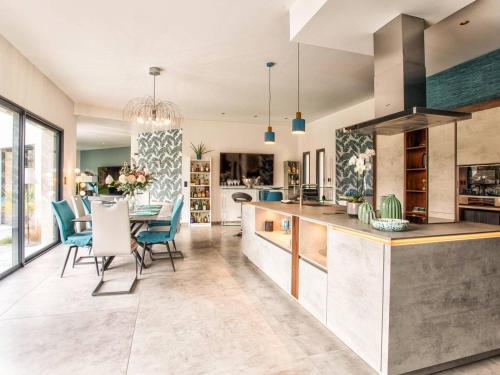 une cuisine et une salle à manger avec une table et des chaises dans l'établissement Maison élégante avec jacuzzi, confort moderne et histoire à Ranville - FR-1-788-44, à Ranville