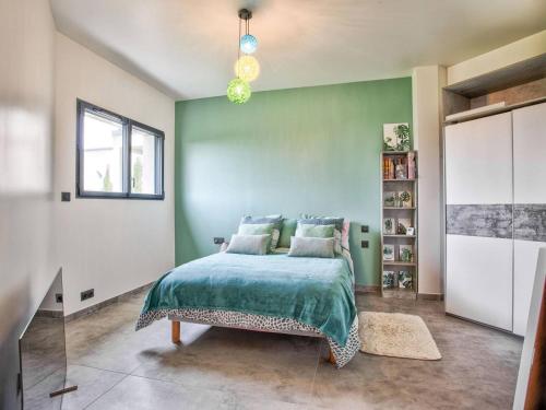 une chambre avec un lit et un mur végétal dans l'établissement Maison élégante avec jacuzzi, confort moderne et histoire à Ranville - FR-1-788-44, à Ranville