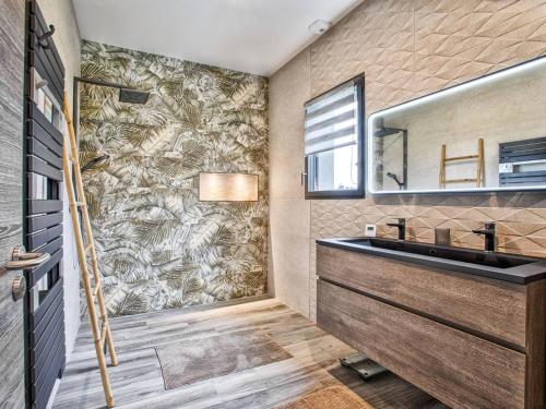 une salle de bain avec un lavabo et un miroir dans l'établissement Maison élégante avec jacuzzi, confort moderne et histoire à Ranville - FR-1-788-44, à Ranville