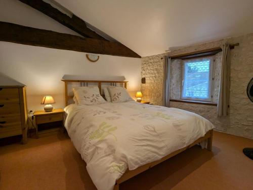 a bedroom with a large bed and a window at Gîte spacieux avec piscine chauffée, jardin, WIFI et animaux admis - FR-1-653-273 in Angeduc