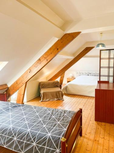 - une chambre mansardée avec un lit et un canapé dans l'établissement Gîte 