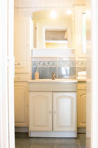 une cuisine avec des armoires blanches et un évier dans l'établissement Gîte 