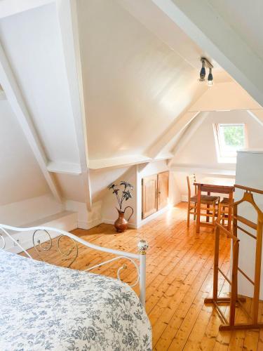 Cette chambre mansardée comprend un lit et une table. dans l'établissement Gîte 