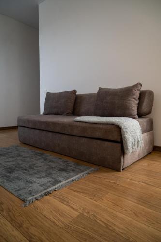 a brown couch in a living room with a rug at Kamyanka in Mizhhirʼʼya