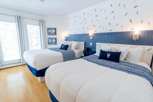 two beds in a hotel room with birds on the wall at The Edgewater in Old Orchard Beach