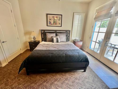 Un dormitorio con una cama grande y una ventana grande. en Gorgeous Ground Floor Villa Near Main Pool, en La Quinta