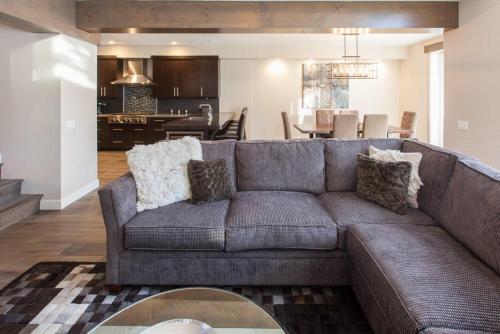 a living room with a gray couch and a kitchen at Snowcreek #754 - Phase V in Mammoth Lakes