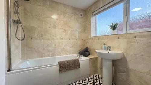 a bathroom with a tub and a sink and a shower at Sea Blue House, Cullercoats in Cullercoats