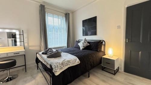a bedroom with a bed and a desk and a window at Sea Blue House, Cullercoats in Cullercoats