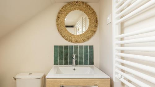 une salle de bain avec un lavabo et un miroir dans l'établissement Cocon de la Tour - Chambre 1 - Hypercentre, à Troyes