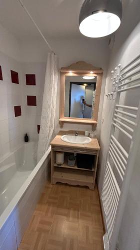 une salle de bain avec un lavabo, une baignoire et un miroir dans l'établissement Charming Apartment with a View, à Puy-Saint-Vincent