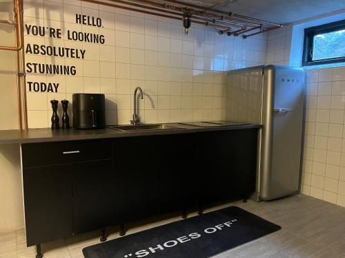 a kitchen with a sink and a refrigerator at F5 Lägenhetssvit på Österlen med det lilla extra! in Tomelilla
