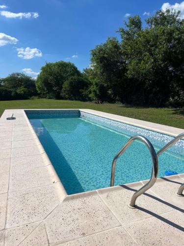 a swimming pool with a chair next to it at Quinta lo de Dito in Villa Allende