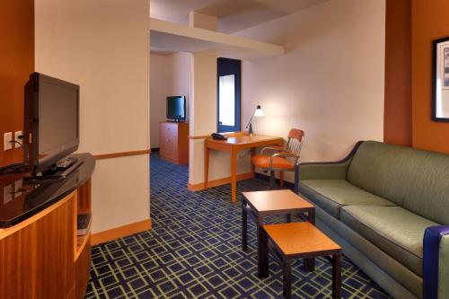 a hotel room with a couch and a tv at Fairfield Inn and Suites by Marriott Laramie in Laramie