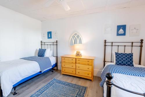 a bedroom with two beds and a dresser with a lamp at The Edgewater in Old Orchard Beach