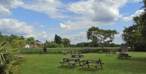 a group of picnic tables in a grass field at The Falcon At Hatton in Hatton