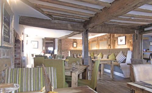 a restaurant with tables and chairs in a room at The Falcon At Hatton in Hatton