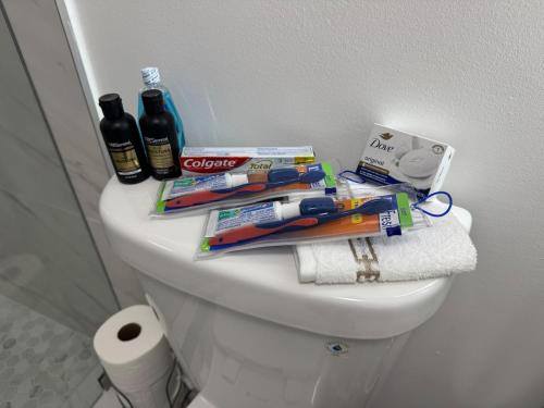 a white toilet with toothbrushes toothpaste and other items on it at Modern Apartment Miami Oasis in Miami