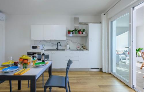 a kitchen with white cabinets and a table and chairs at Albamare in Alba Adriatica