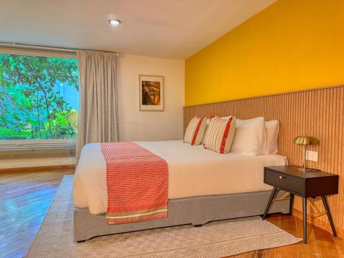 a bedroom with a large bed and a window at Hotel Boutique Casa Alebrije in Mexico City