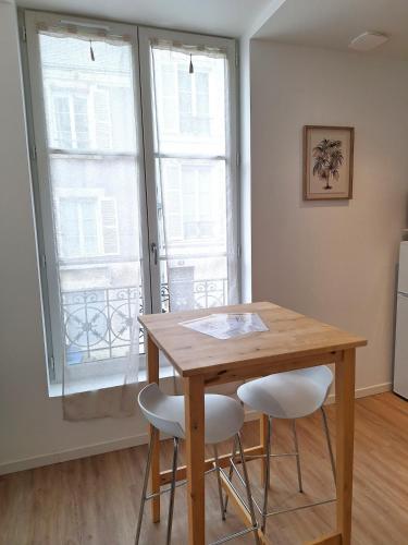 une cuisine avec une table en bois et deux chaises dans l'établissement Notre Dame 3 - Très belle vue sur la Loire - Lumineux - Hypercentre, à Orléans