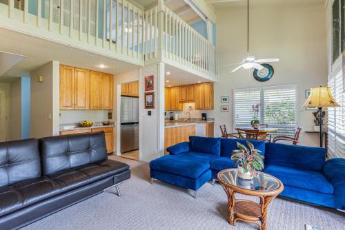 a living room with blue couches and a table at Puamana 9C in Princeville