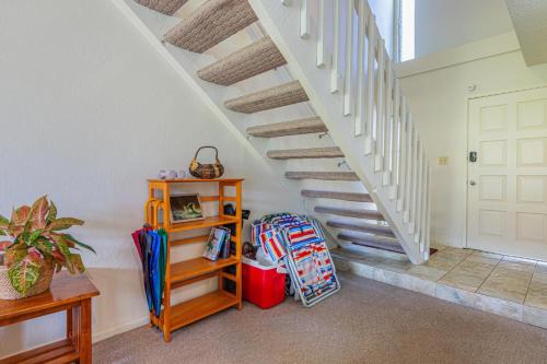 a room with a staircase with a book shelf and luggage at Puamana 9C in Princeville