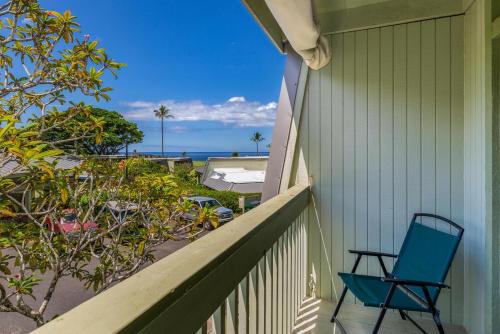 a blue chair sitting on a porch looking out at the ocean at Puamana 9C in Princeville