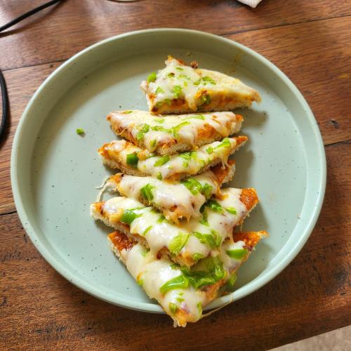 een bord met vier stukken pizza op een tafel bij The Amba Resort in Chandoli