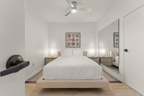 a white bedroom with a bed and a mirror at Tides 611 in Destin