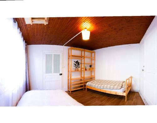 - une chambre avec 2 lits et un banc dans l'établissement Grande Chambre avec Home Cinéma, à Morez