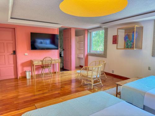 a room with a bed and a table and chairs at Hotel Boutique Casa Alebrije in Mexico City