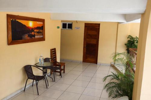 a dining room with a table and chairs and a door at Hotel Real Monrey in Zihuatanejo