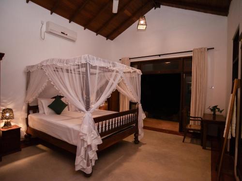 a bedroom with a bed with a canopy at The Lush Unawatuna in Unawatuna
