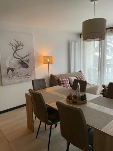 - un salon avec une table à manger et des chaises dans l'établissement Gîte Les Lilas, à Gérardmer