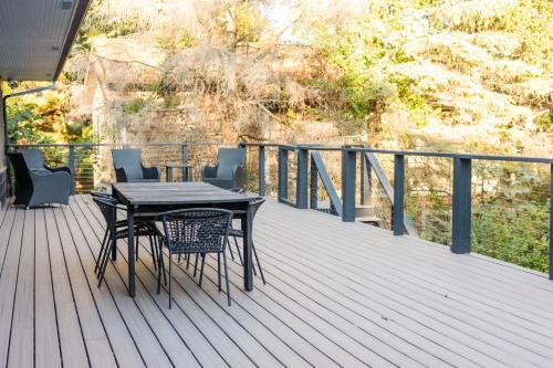 Una terraza de madera con una mesa y sillas. en The Great Escape Blocks From Your Private Beach, en New Buffalo