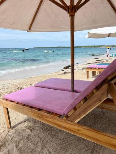 a bed on a beach with an umbrella at AcapulcoBeach in Playa Blanca