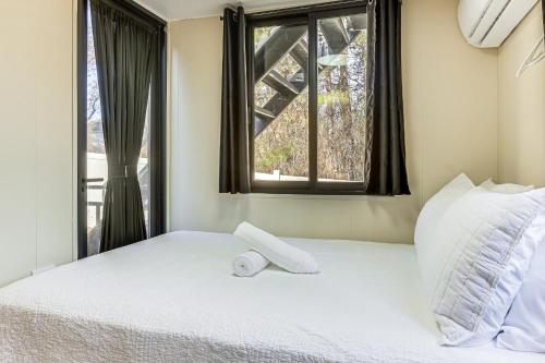 ein Schlafzimmer mit einem weißen Bett mit einem Fenster in der Unterkunft 5 Mi to Stone Mountain Lithonia Getaway in Lithonia
