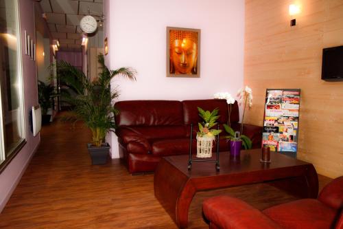 un salon avec un canapé en cuir et une table dans l'établissement Hotel - Restaurant du Lac - Agen, à Boé