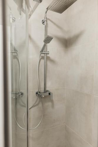 a shower with a glass door in a bathroom at Macao Apartmani in Vinkovci