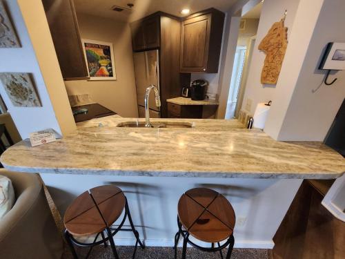a kitchen with a sink and two bar stools at North Shore Inn TC 302 in Traverse City