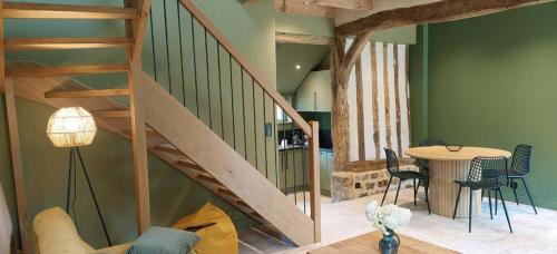un salon avec un escalier et une table dans l'établissement Le Cottage -Gîte de charme-, à Boudeville