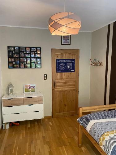 a bedroom with a bed and a dresser and a door at Gîte mon chez moi in Soucht
