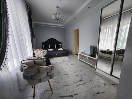 a bedroom with a bed and a mirror and a chair at Київські Ночі in Kyiv